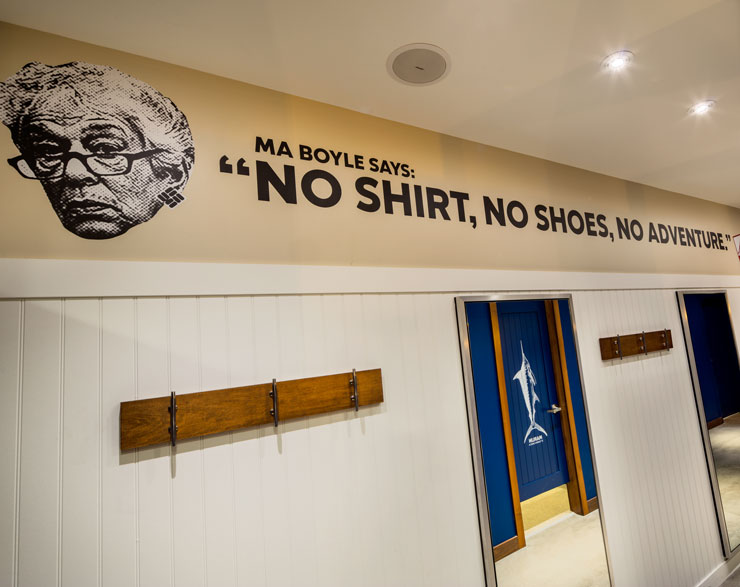 Columbia fitting rooms with a wall graphic that reads, "Ma Boyle says: 'No shirt, no shoes, no adventure.'"
