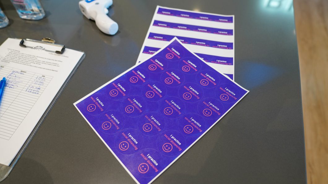 Stickers that say “I practice social distancing” are available to all employees at sign in.