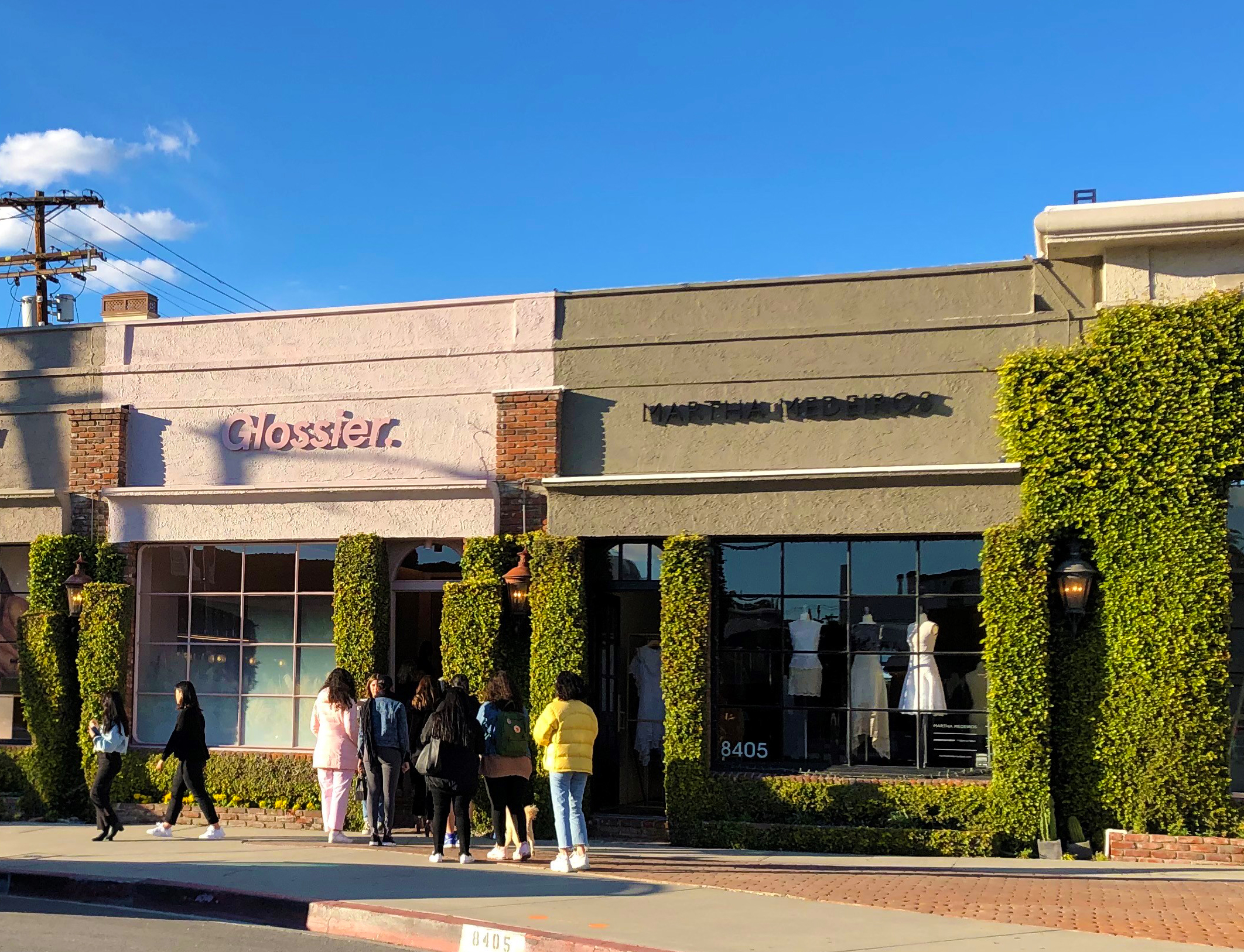 Shoppers wait in line to enter Glossier in California.