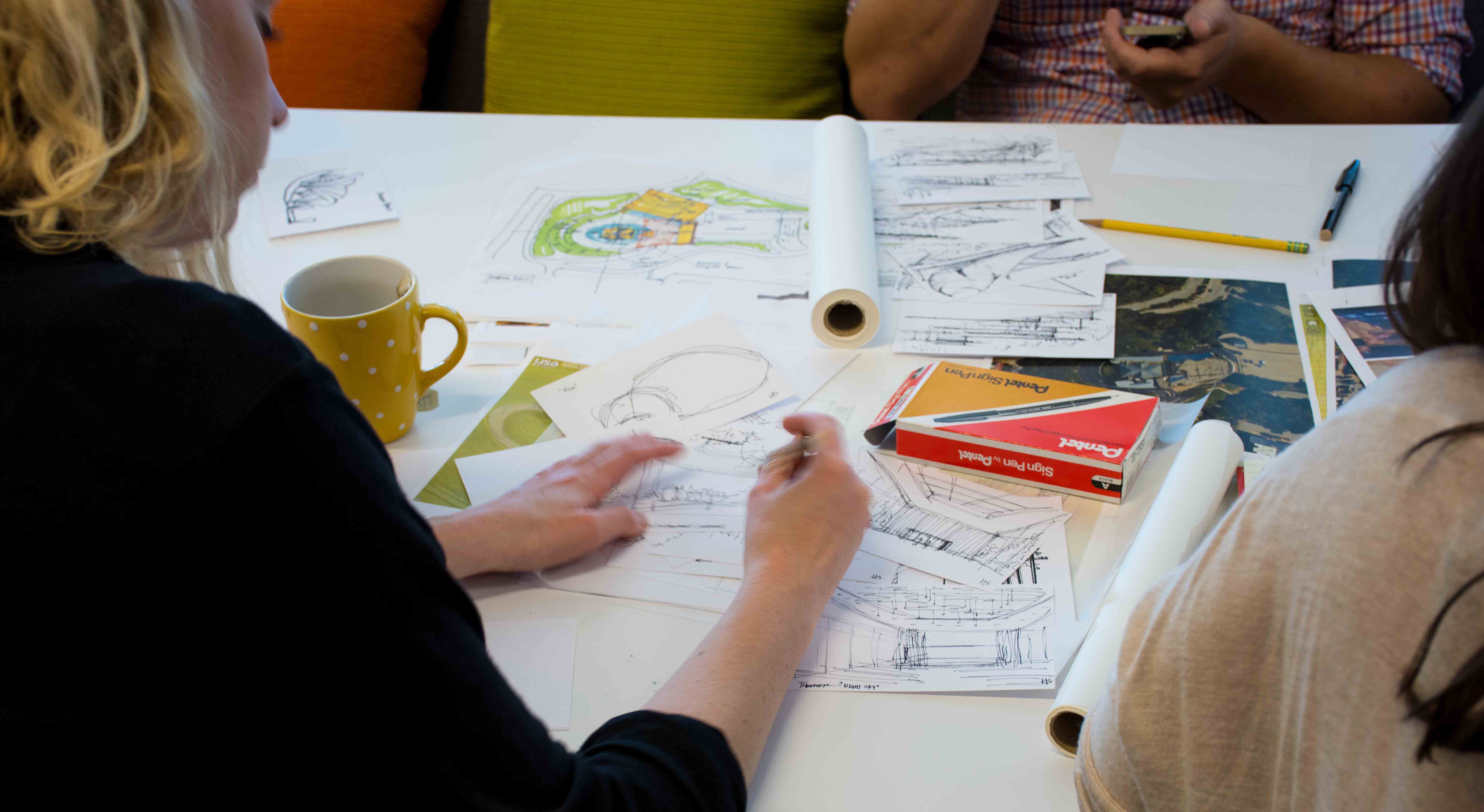 Woman sketching on paper in a meeting