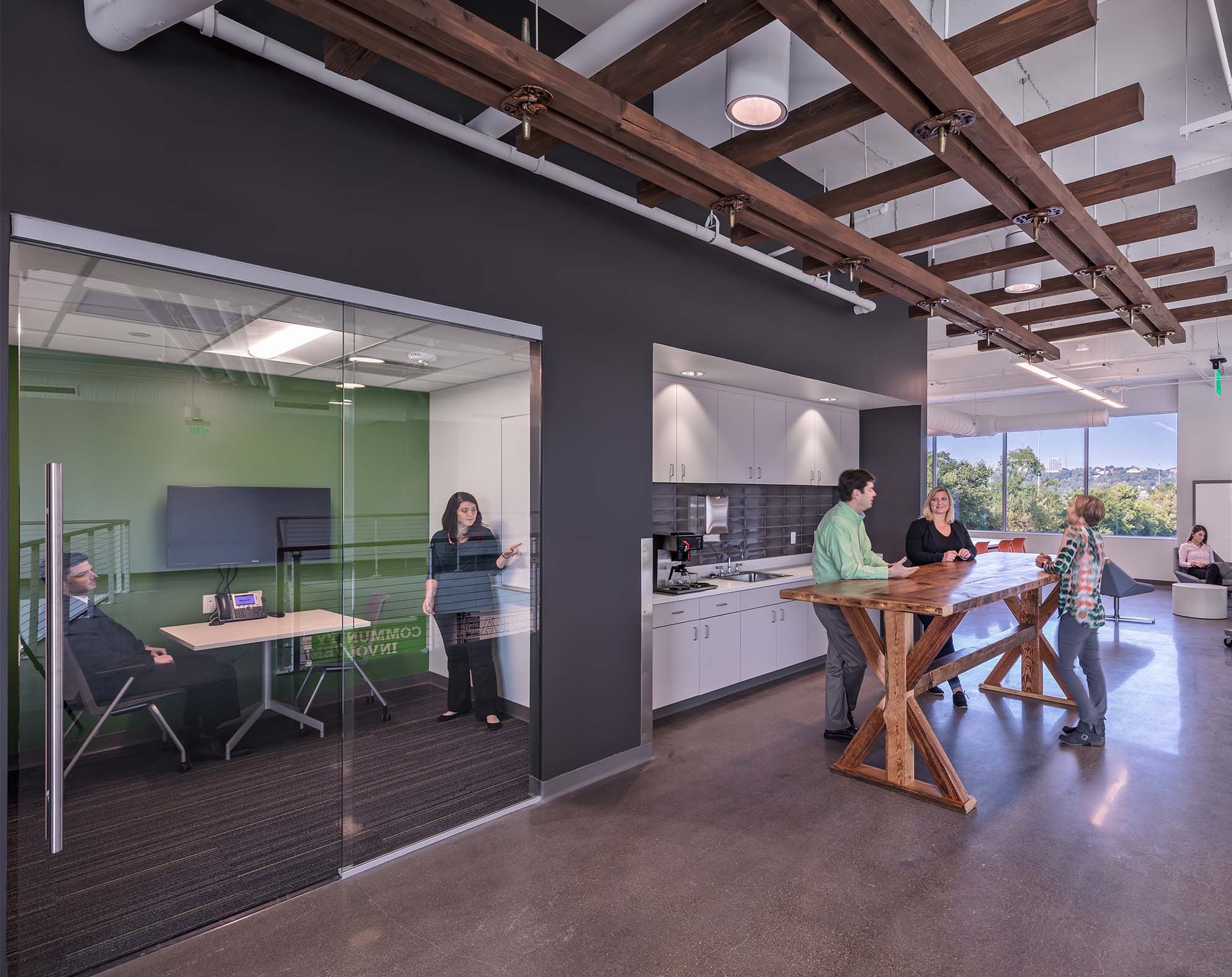 A huddle room is seen next to the small kitchen area