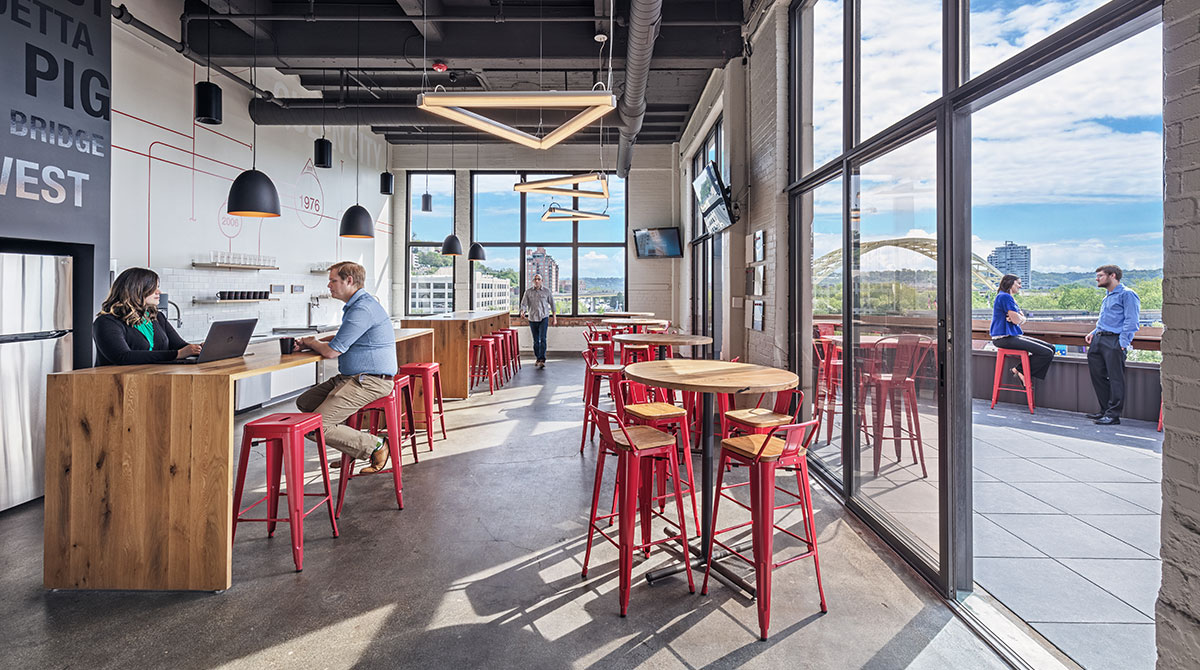 Employees sit at bar-style tables in the kitchen area