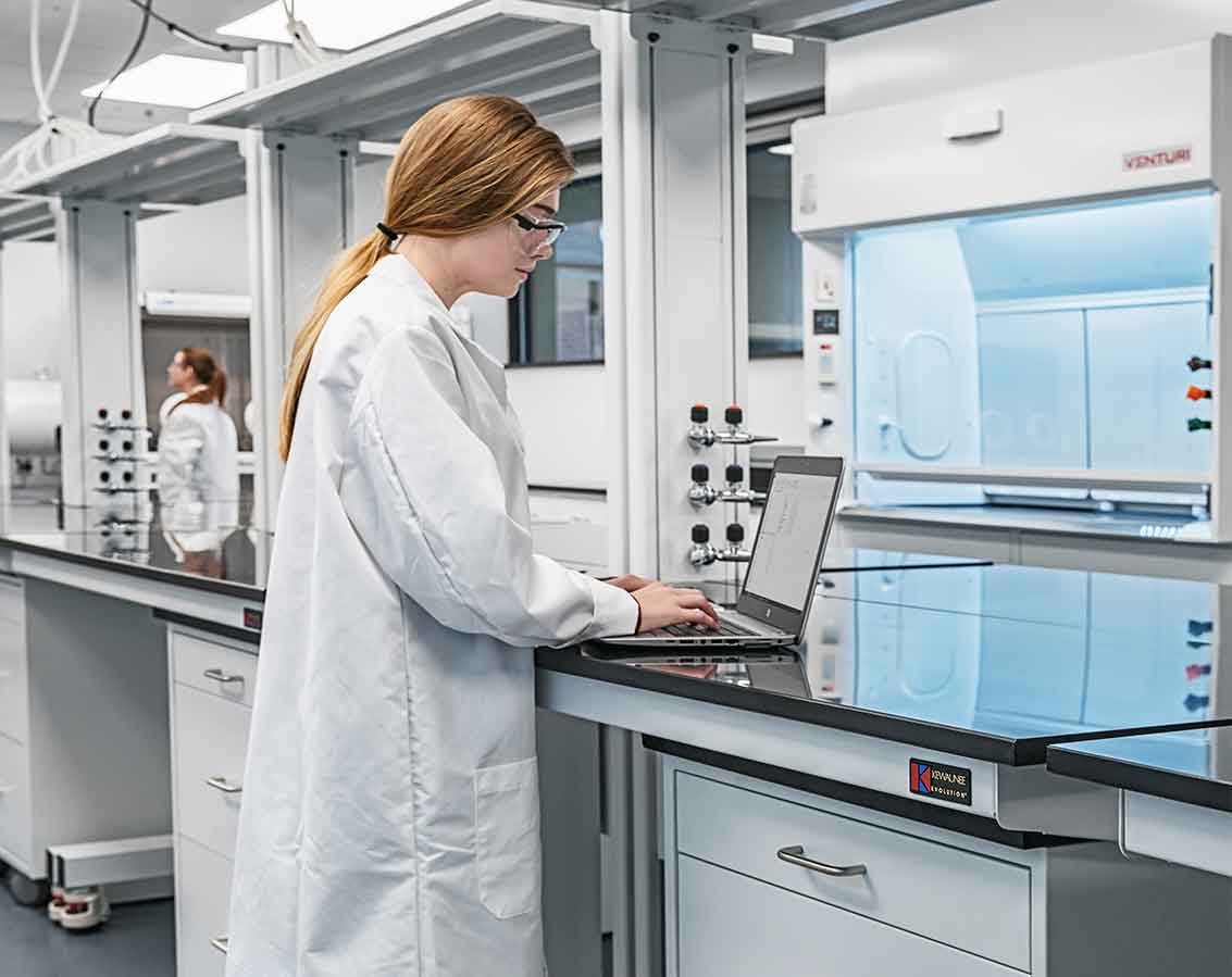 A female student works on her laptop inside a lab