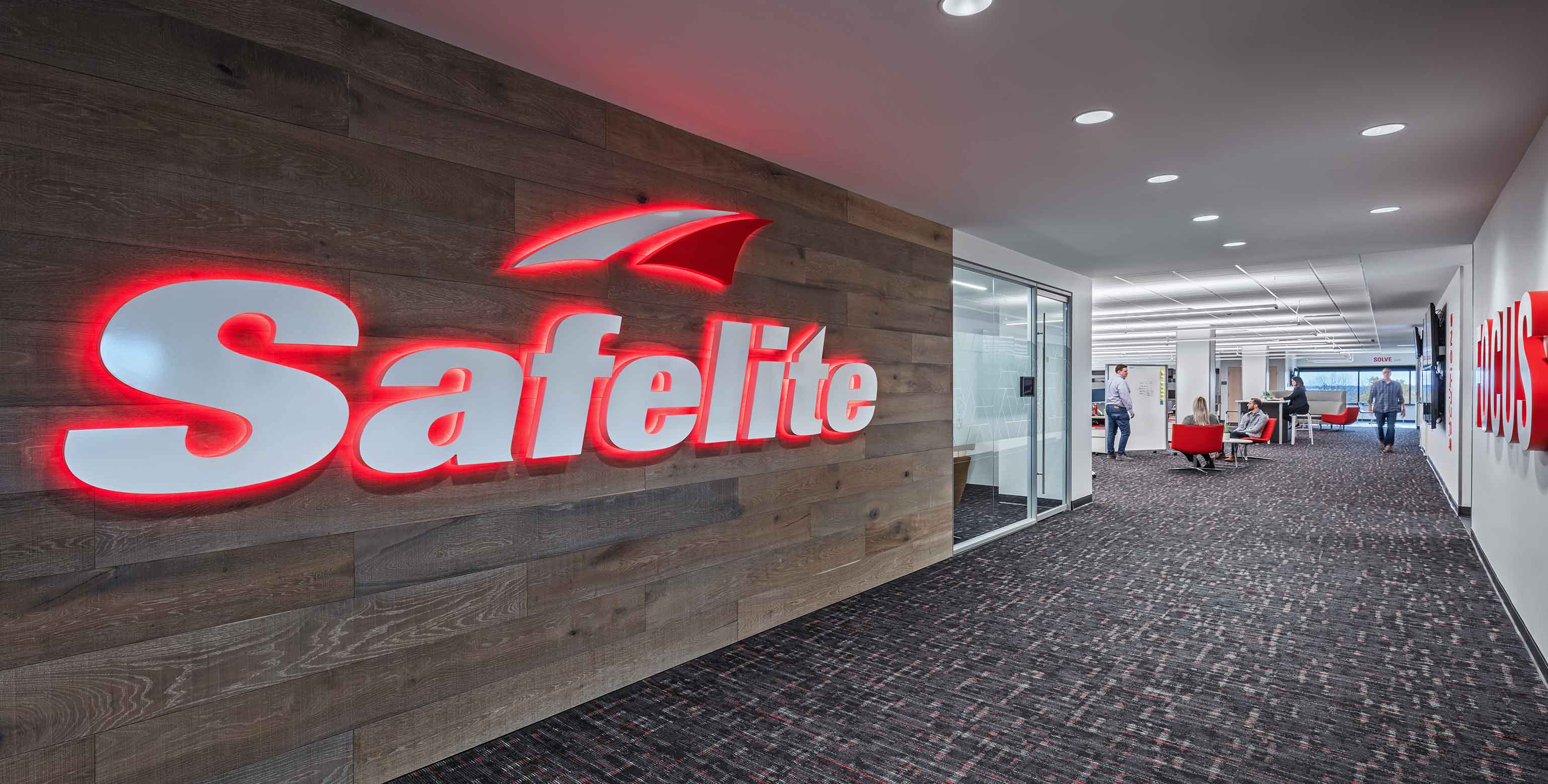 Safelite's logo shines bright on a wood panel wall