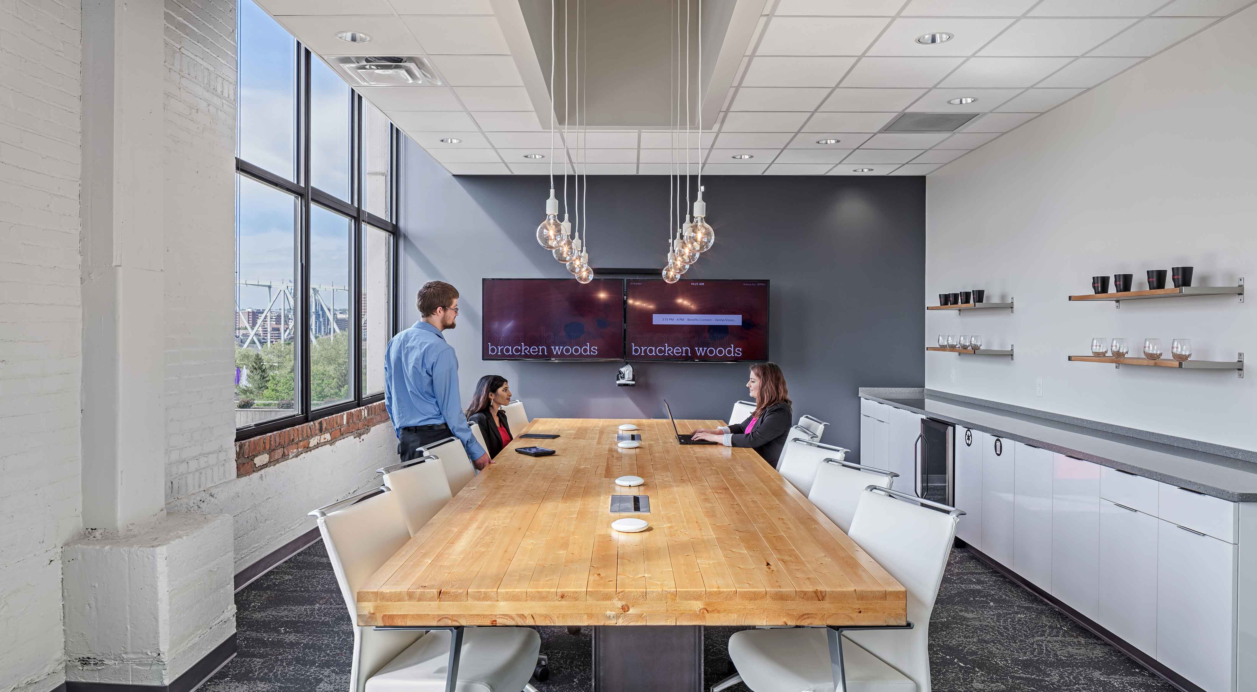 Employees gather in a conference room around a handmade table