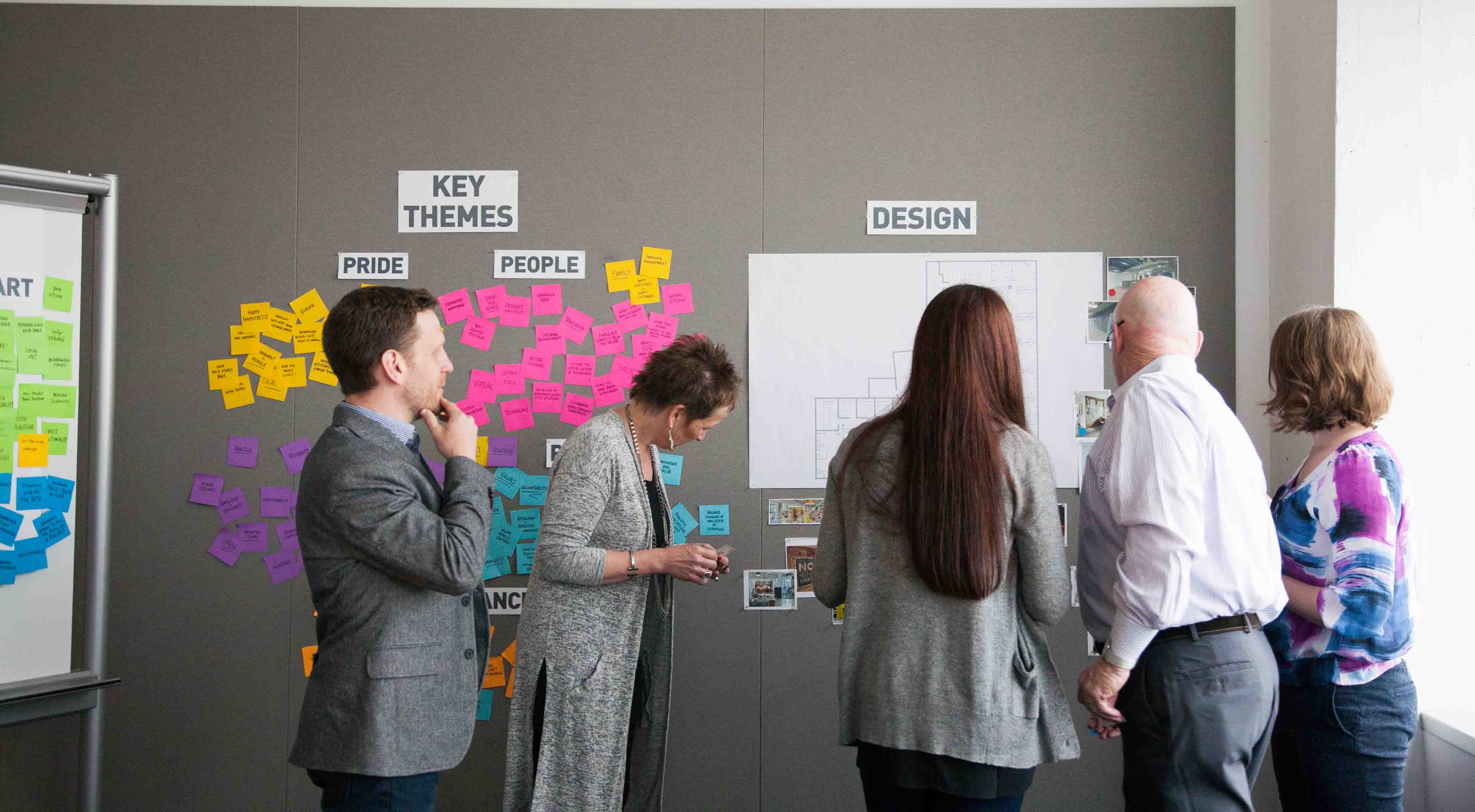 Three women and two men stand in discussion