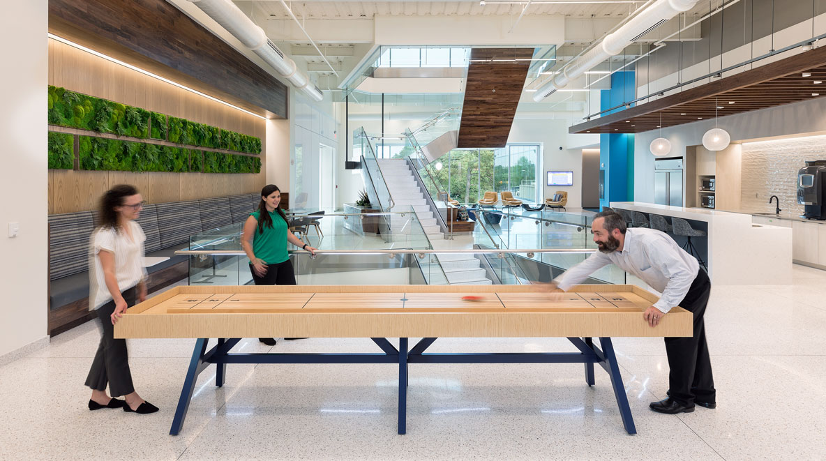 Three people playing table top shuffle board at Altria HQ