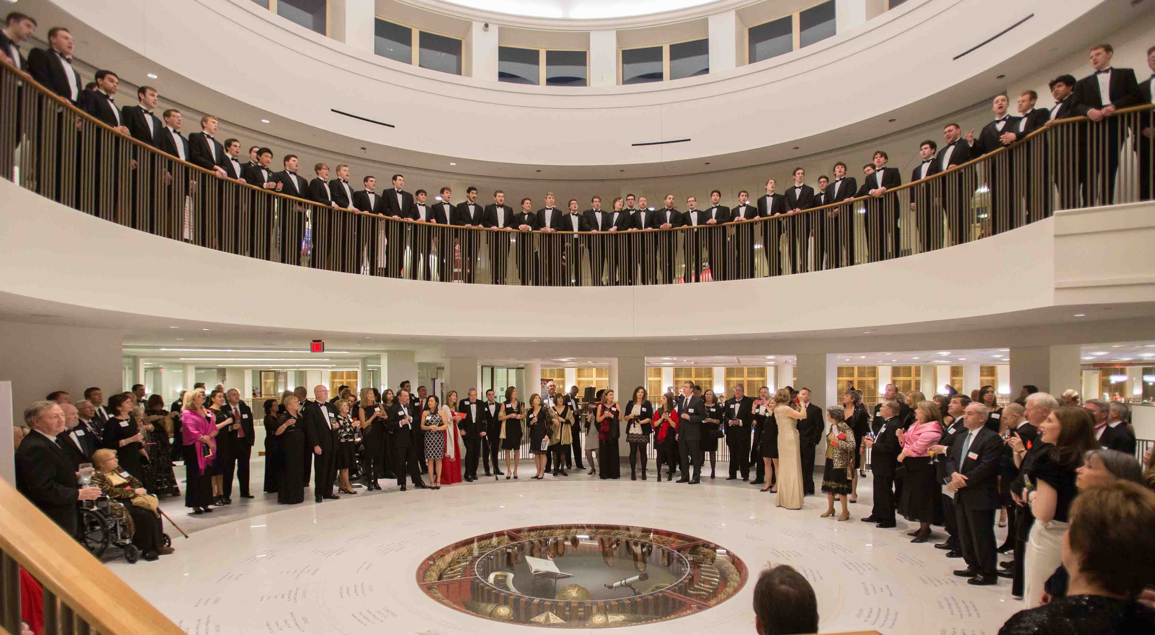 A glee club sings from the second floor of the Armstrong Student Center rotunda to a crowd below