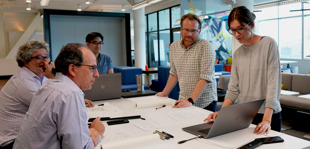 Designers collaborate around a table