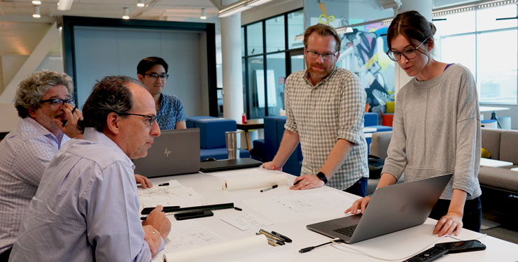 Designers collaborate around a table