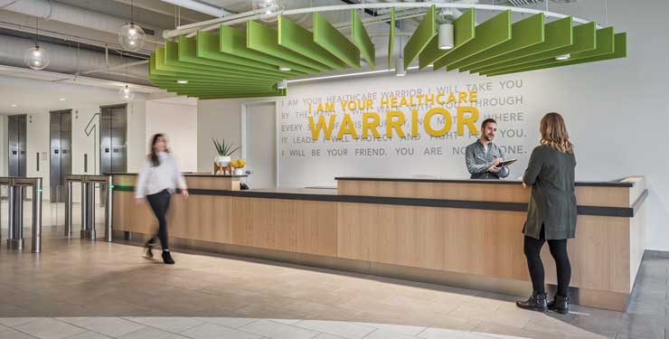 View of Quantum Health's front desk and branded lobby wall