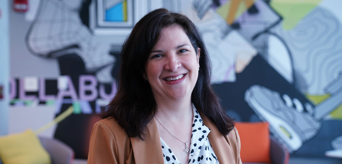 Company headshot of Michelle Lopez Orsini with artistic mural background