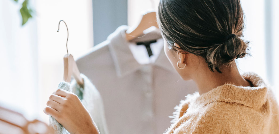 Woman shopping and choosing between two shirts