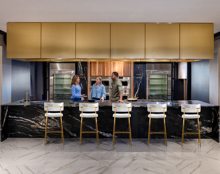 Customer, architect, and employee speaking in luxury kitchen display