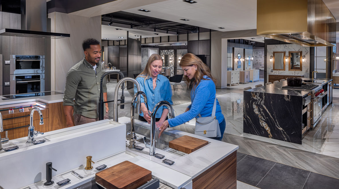 Customer testing sink fixtures within the Ferguson Studio Showroom