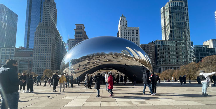 People viewing and interacting with Cloud Gate (The Bean) in Chicago, IL.