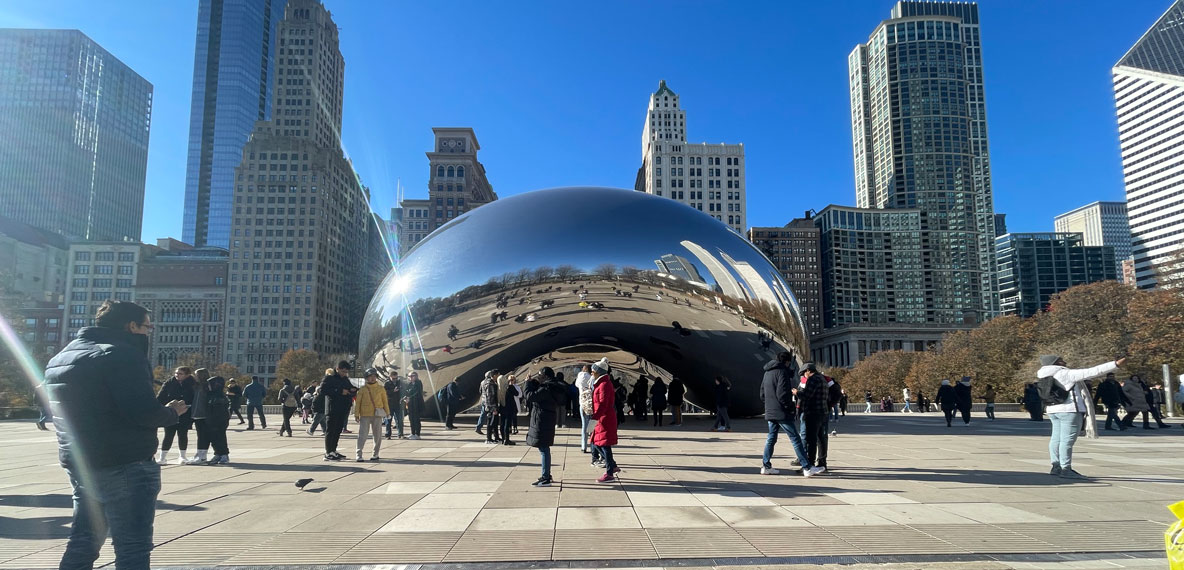 People viewing and interacting with Cloud Gate (The Bean) in Chicago, IL.