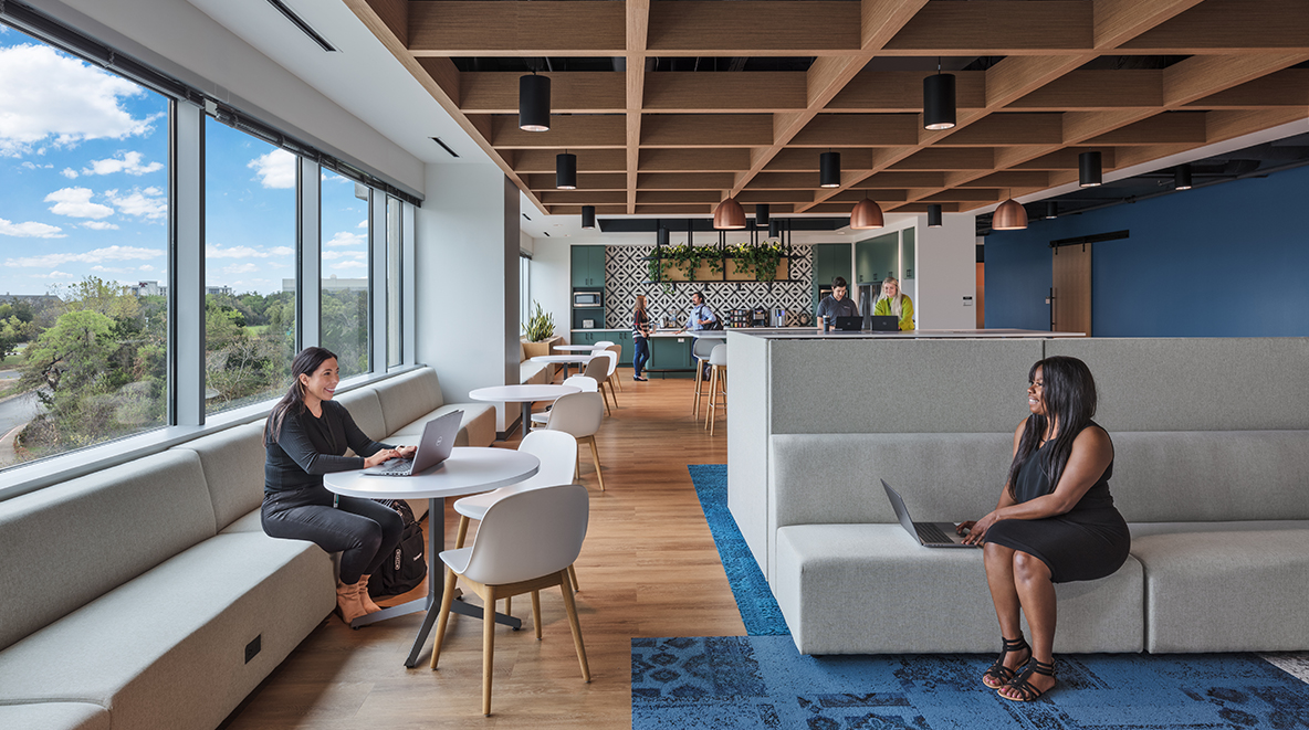 Two women Forcepoint employees converse in the common room.