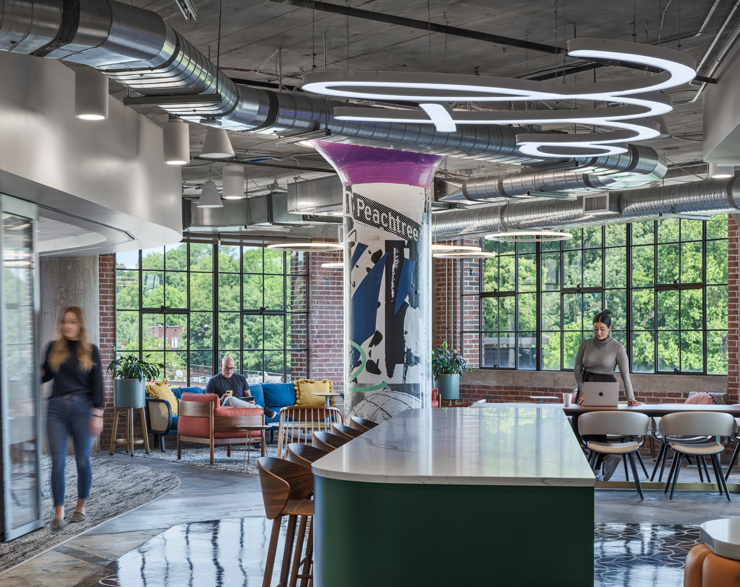 Tables throughout the office allow employees to have meetings, eat lunch, and do work away from a desk.