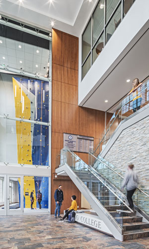 Interior of Krapf Gateway Center, featuring students and a rock climbing wall.