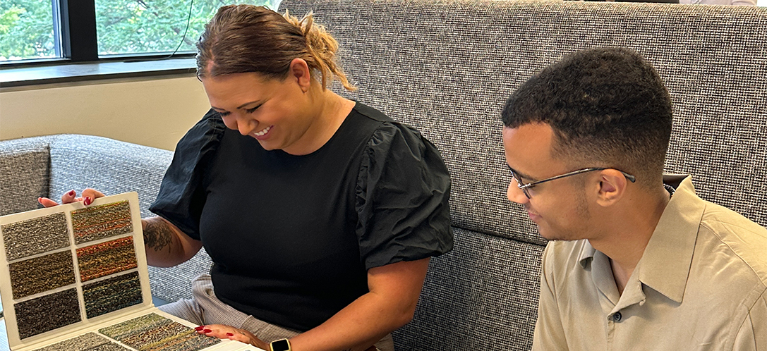 Interns Mollie Kunar and Eduardo Cabrera look at carpet samples.