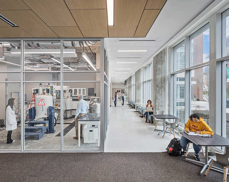 Student studying while enjoying a view into the laboratories.