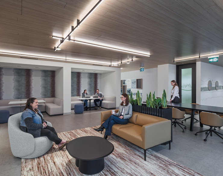 Employees chat on couches in an open collaboration area