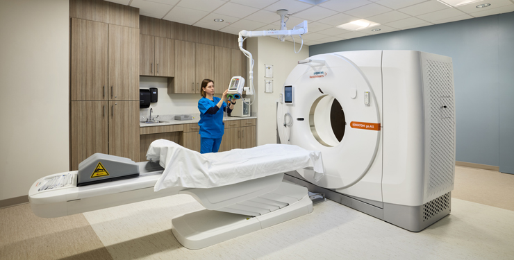 An medical professional uses the CT scanner 