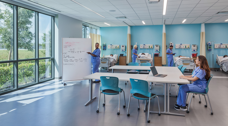 Nursing students work through a problem together using a white board
