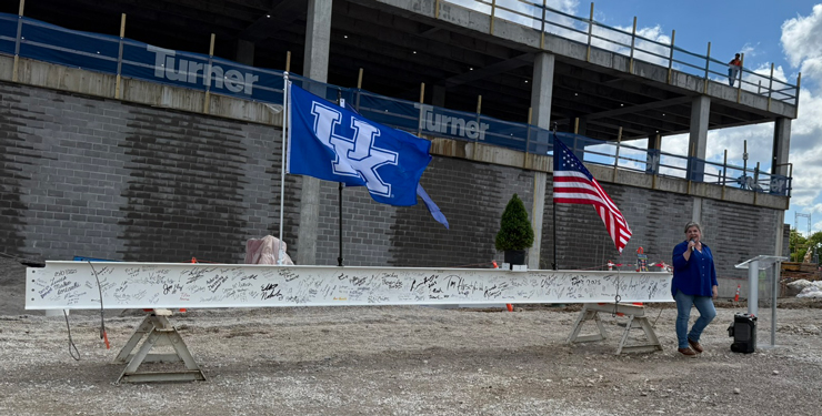 A construction beam is on display with hand-written signatures all over it