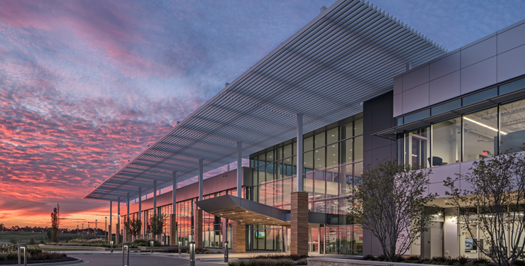 A red and pink sunset is shown in the background of a prominent building