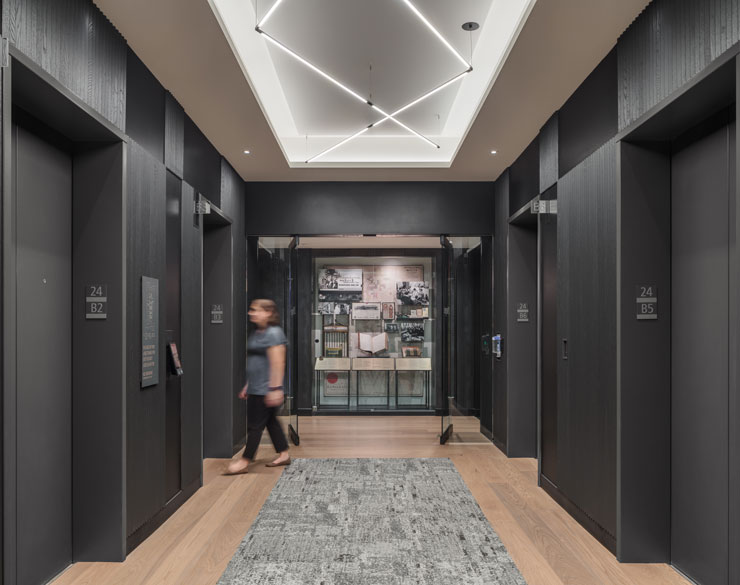 Elevator room wit light wood floors and black walls