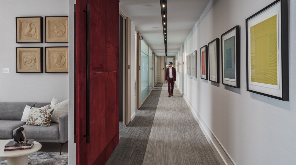 Man in hallway with art hung up