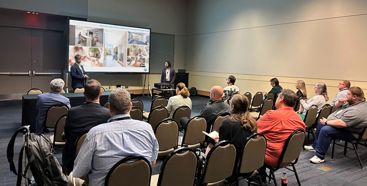 Mike Garvey and Alejandro J. Medina presenting in front of a crowd