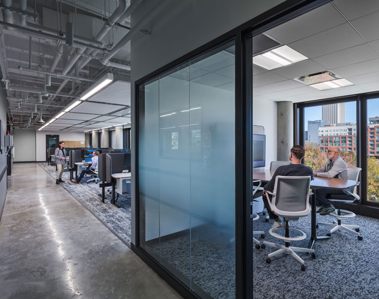 Hallway looking into an office with two men inside