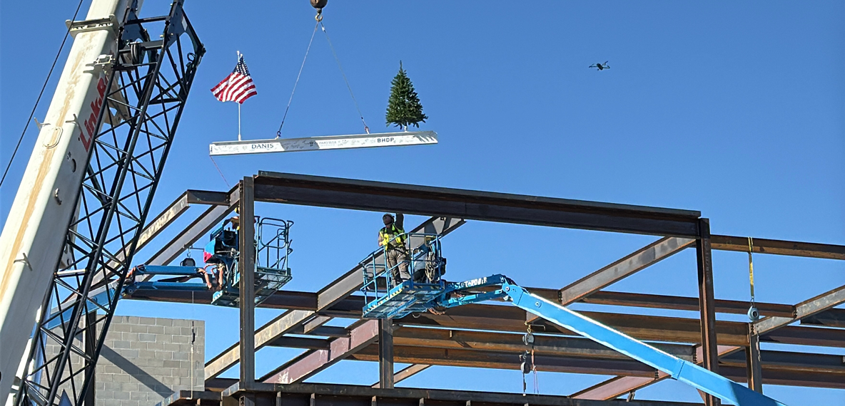 The final beam being placed on the three-story academic center.
