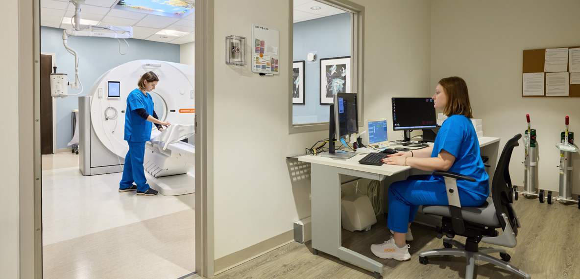 Two healthcare workers prepping a room for a patient.