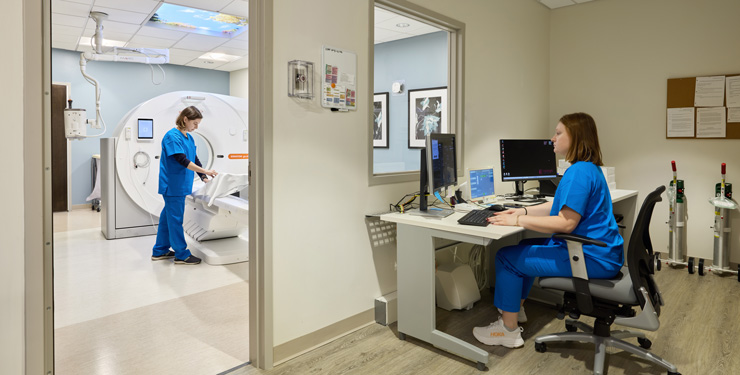 Two healthcare workers prepping a room for a patient.