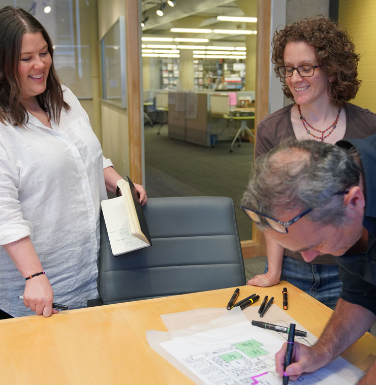 Columbus employees gather around a designer sketching