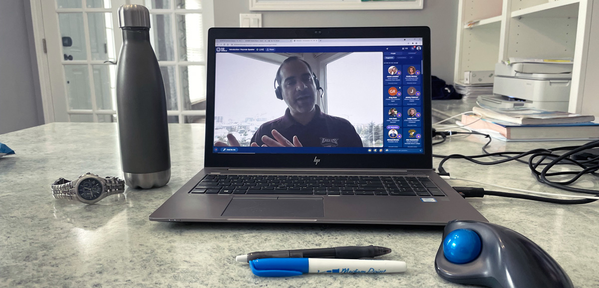 A computer is set up on a desk and on the screen a person is presenting