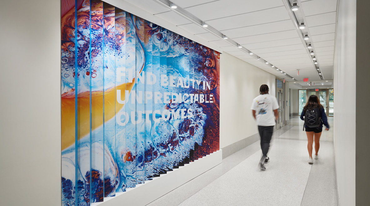 A lenticular wall states, "Find beauty in unpredictable outcomes."