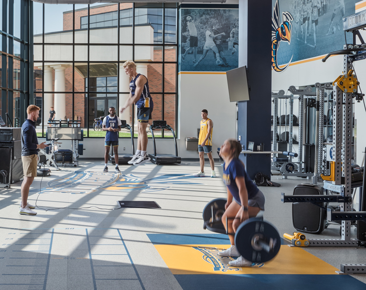 Student athletes work out in their new weight room