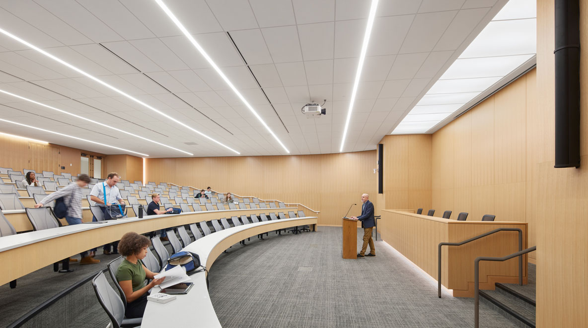 Students take their seats in a large classroom functioning as a mock trial room