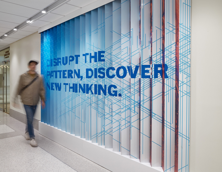 A lenticular wall states, "Disrupt the pattern, discover new thinking."