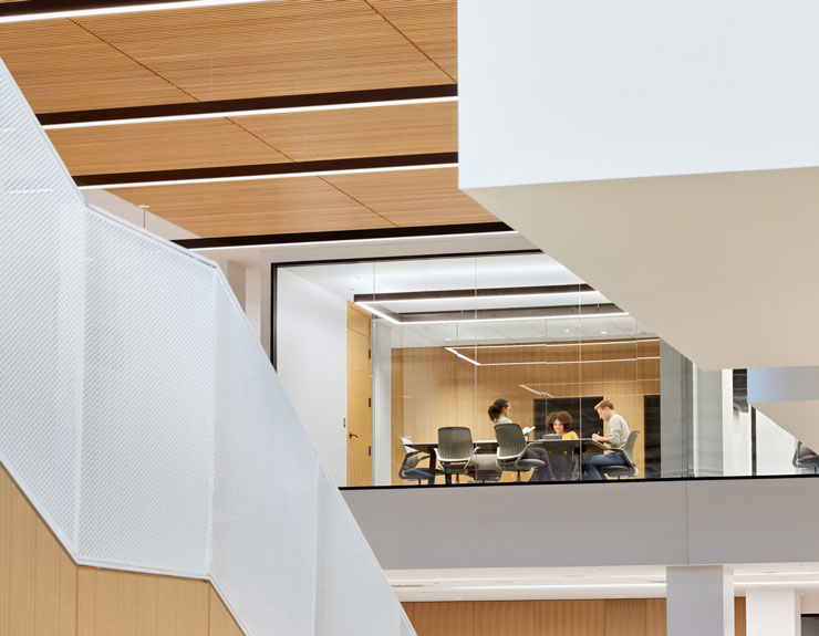 An all-glass conference room is visible in the atrium