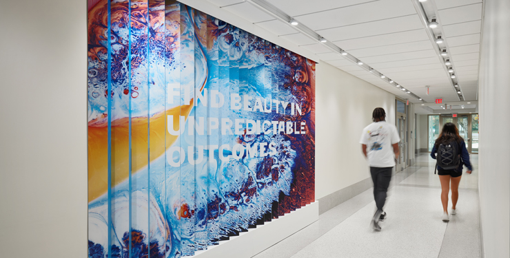 A lenticular wall states, "Find beauty in unpredictable outcomes."
