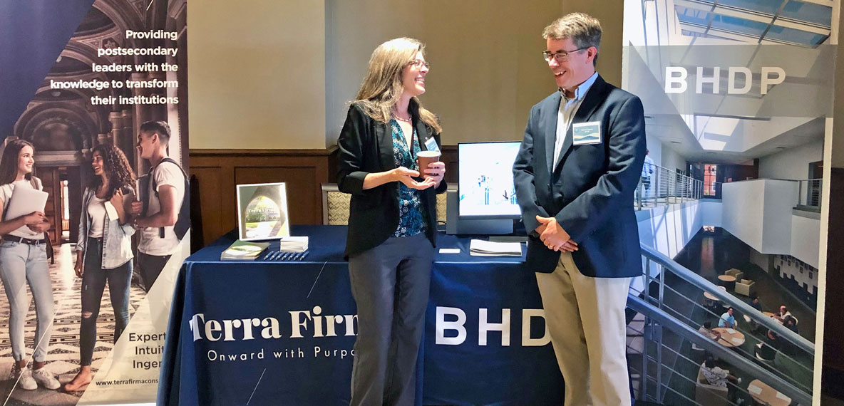 Two people stand in front of a booth for BHDP and Terra Firma