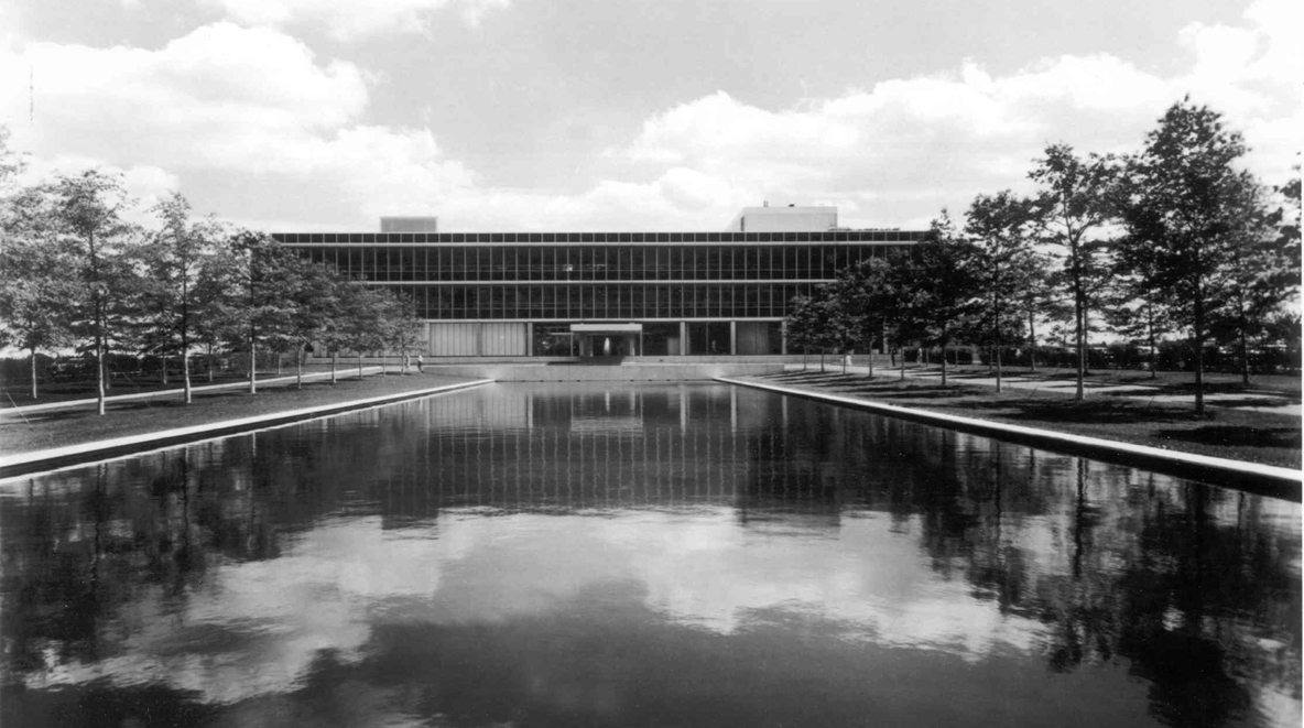 A large reflecting pool flanked by willow trees welcomes visitors and employees onto the site.