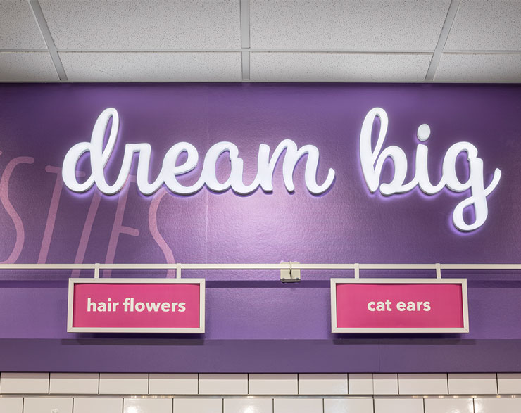 "Dream Big" sign is illuminated in lights on a purple wall