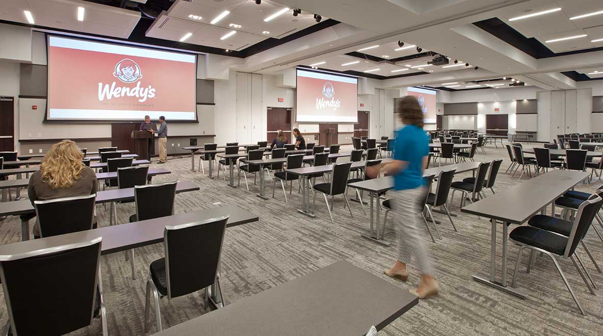 A modern conference room with two large projector screens.